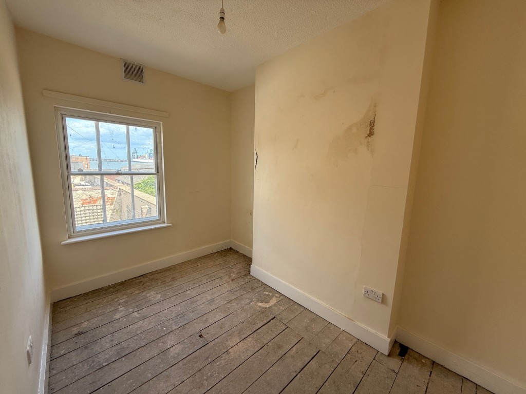 Lot: 127 - THREE-BEDROOM END-TERRACE COTTAGE FOR IMPROVEMENT - Bedroom one with window to front and view towards sea